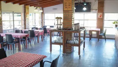 a dining room with tables and chairs in a restaurant at Winds Hill Resort & Spa in Merlo