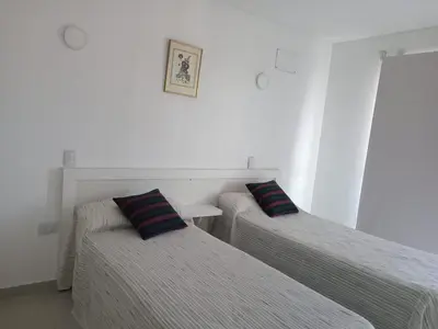 two beds in a white room with two pillows at Edificio Leonardo departamento 16 in Villa Carlos Paz