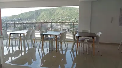 a room with tables and white chairs and a large window at Edificio Leonardo departamento 16 in Villa Carlos Paz