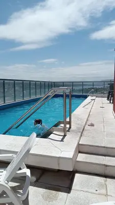 a swimming pool with a dog in the water at Edificio Leonardo departamento 16 in Villa Carlos Paz