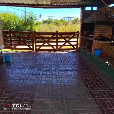a wooden fence on a patio with a field in the background at Pecas house in Mina Clavero