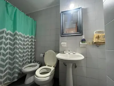 a bathroom with a toilet and a sink and a mirror at Nueva Córdoba departamento de una habitacion con vista al Parque in Cordoba