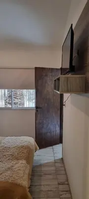 a bedroom with a bed and a tv on the wall at Departamento Costa Paz in Villa Carlos Paz