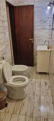 a bathroom with a toilet and a sink and a tub at Departamento Costa Paz in Villa Carlos Paz