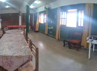 a room with two beds and a table and windows at Pecas house in Mina Clavero