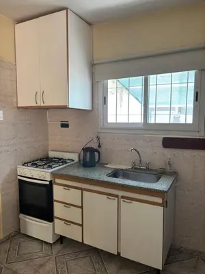 a small kitchen with a stove and a sink at Casa céntrica en calle CB 297 in Villa Carlos Paz
