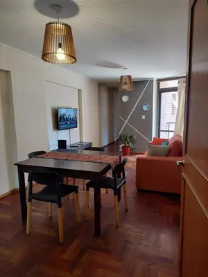 a living room with a table and a couch at Dpto dos dormitorios en Nueva Córdoba in Cordoba