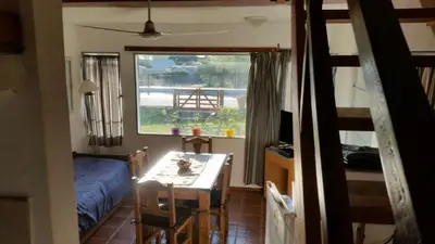 a bedroom with a bed and a desk and a window at Cabañas Mirador de la Bahia in Villa Ciudad Parque