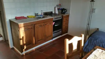a kitchen with a sink and a stove top oven at Cabañas Mirador de la Bahia in Villa Ciudad Parque