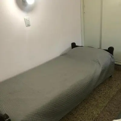 a bed sitting in a corner of a room at Wynwood Extreme Hostel in Villa Carlos Paz
