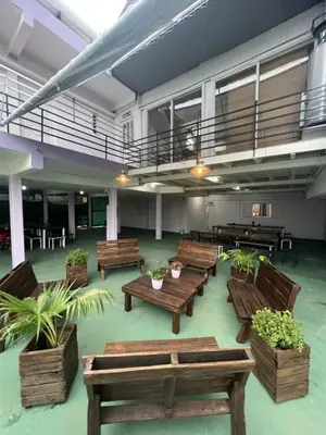 a room with wooden benches and potted plants at Wynwood Extreme Hostel in Villa Carlos Paz