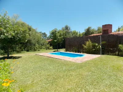 a backyard with a swimming pool in the grass at La cabañita de Maco in Nono