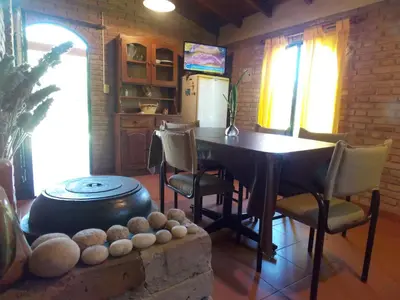 a kitchen with a table and chairs and a stove at La cabañita de Maco in Nono