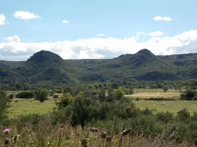a view of a field with mountains in the background at La cabañita de Maco in Nono