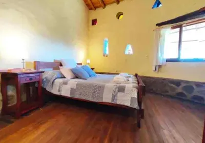 a bedroom with a bed and a wooden floor at El Lugar in Travesía