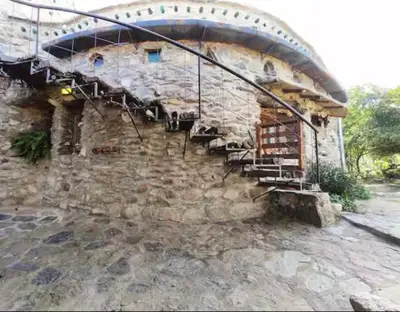 a stone building with a staircase in front of it at El Lugar in Travesía