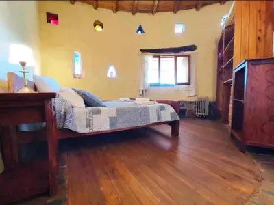 a bedroom with a bed and a wooden floor at El Lugar in Travesía