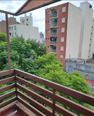 a wooden bench in a city with buildings at Temporarios Cordoba in Cordoba