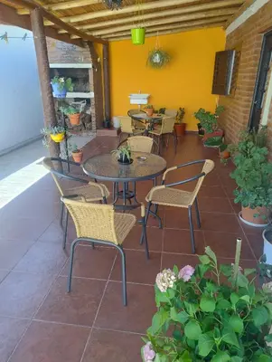 a patio with tables and chairs and some plants at Sierras Alojamiento Departamentos in Mina Clavero