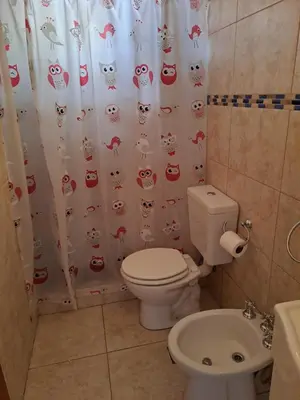 a bathroom with a toilet and a shower curtain with cats at PARQUE DEL SIERRAS in Alta Gracia