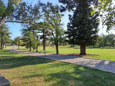 a path in a park with trees and grass at PARQUE DEL SIERRAS in Alta Gracia