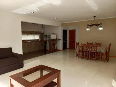 a living room and kitchen with a couch and a table at Sueños de Montaña in Villa Yacanto