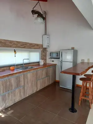 a kitchen with a wooden counter top and a wooden table at Sueños de Montaña in Villa Yacanto
