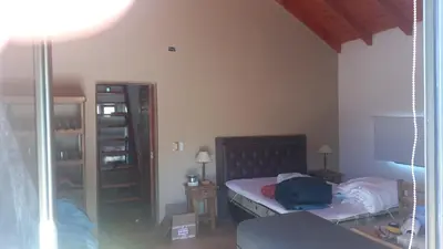 a small bedroom with a bed and a mirror at Sueños de Montaña in Villa Yacanto