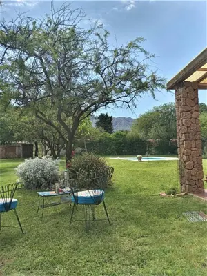 a table and chairs in a yard with a stone pillar at Las Guardia in Cortaderas