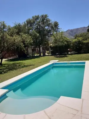a large blue swimming pool in a yard at Las Guardia in Cortaderas
