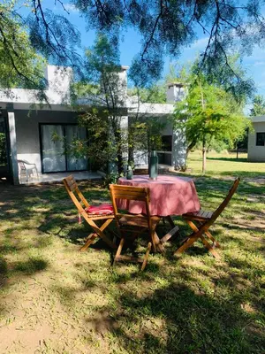 a table and chairs in front of a house at La carolina in Villa de Las Rosas