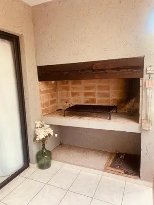 a room with a brick fireplace with a vase of flowers at La carolina in Villa de Las Rosas