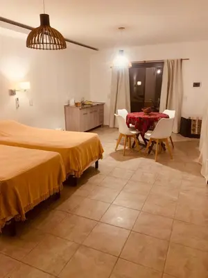 a bedroom with two beds and a table and chairs at La carolina in Villa de Las Rosas