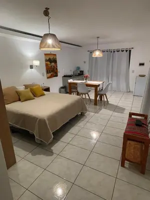 a bedroom with a bed and a table with chairs at La carolina in Villa de Las Rosas