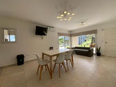 a living room with a table and chairs and a couch at Sunset Village in Villa Carlos Paz