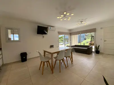 a living room with a dining room table and chairs at Sunset Village in Villa Carlos Paz
