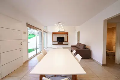 a living room with a white table and a couch at Sunset Village in Villa Carlos Paz