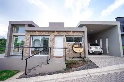 a house with a car parked in front of it at Sunset Village in Villa Carlos Paz