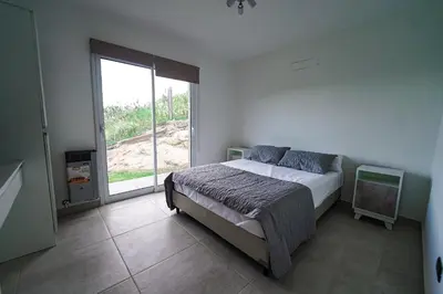 a bedroom with a bed and a large window at Sunset Village in Villa Carlos Paz