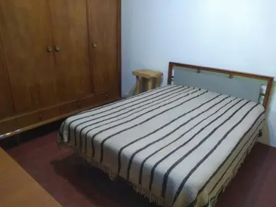 a bed in a room with a wooden cabinet at Casa alma verde in Luyaba