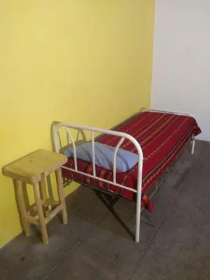 a small bed and a table in a room at Casa alma verde in Luyaba