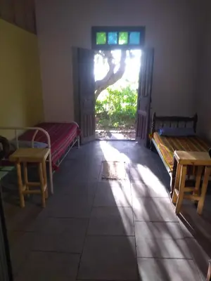 a room with two beds and a window and a door at Casa alma verde in Luyaba