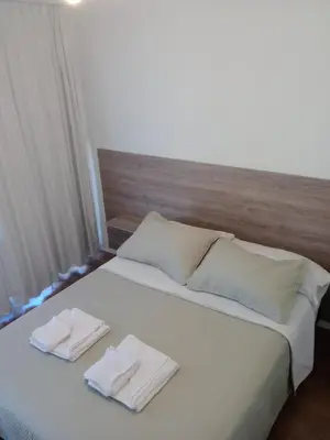 a bed with two white towels on top of it at Depto con Vista PANORAMICA FRENTE CENTRO CIVICO - UBICACION INMEJORABLE in Cordoba