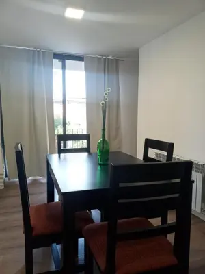 a dining room table with chairs and a vase with flowers on it at Depto con Vista PANORAMICA FRENTE CENTRO CIVICO - UBICACION INMEJORABLE in Cordoba