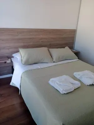 a bed with two white towels on top of it at Depto con Vista PANORAMICA FRENTE CENTRO CIVICO - UBICACION INMEJORABLE in Cordoba