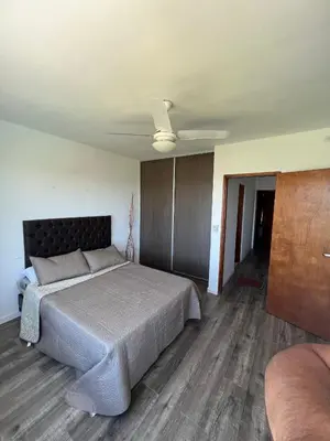 a bedroom with a bed and a ceiling fan at Duplex en plena montaña in Villa Carlos Paz