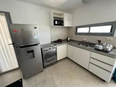 a kitchen with a refrigerator and a washing machine at Duplex en plena montaña in Villa Carlos Paz