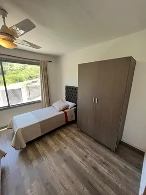 a bedroom with a bed and a large cabinet at Duplex en plena montaña in Villa Carlos Paz