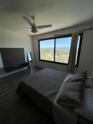 a bedroom with a bed and a large window at Duplex en plena montaña in Villa Carlos Paz