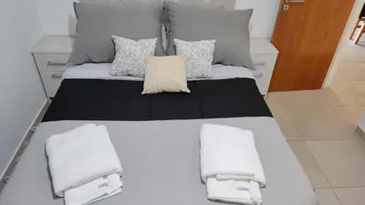 a large bed with two pillows and towels on it at departamento de dos dormitorios in Cordoba